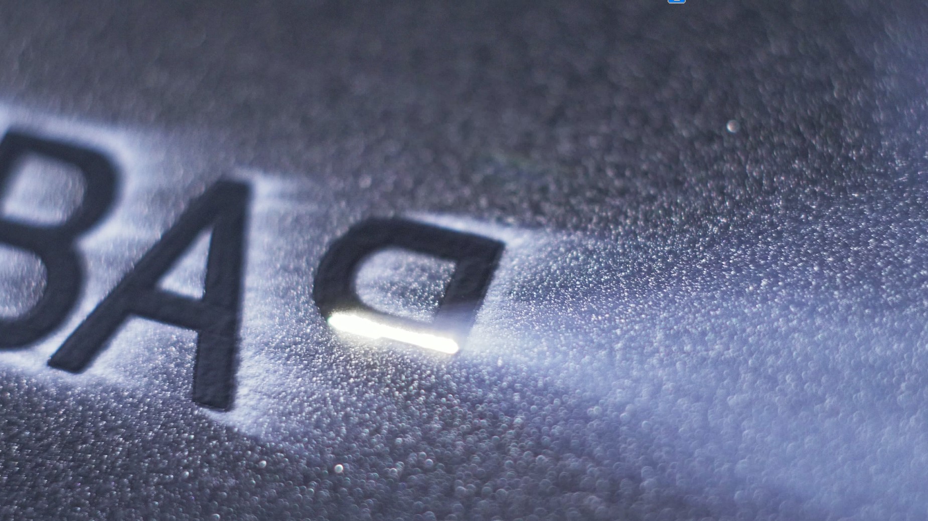 Ein Laser graviert Buchstaben in ein Metallblech