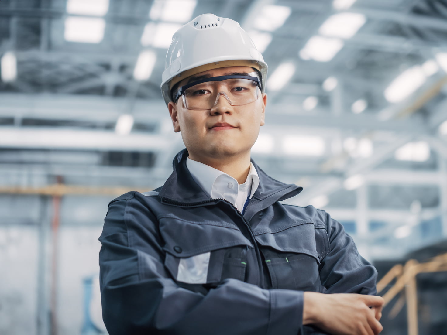 Man wearing a hardhat looking at the camera in a modern factory environment